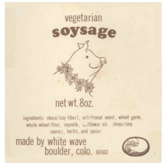 a label from White Wave's vegetarian soysage product, featuring a very late-1970's hand-drawn smiling pig with wiggly ears and a garland of flowers. The listed ingredients include okara (soy fiber), nutritional yeast, wheat germ, whole wheat flour, soymilk, safflower oil, and shoyu.